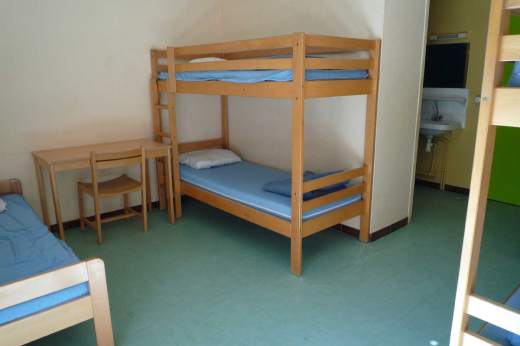 Chambre collective de 5 places avec 2 lits superposés et 1 lit simple située dans lhébergement Lou Sanglier